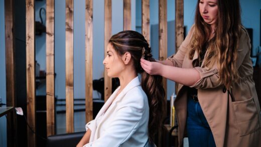 Hairstylist doing a hairstyle for a bride for her wedding day at the hair salon.