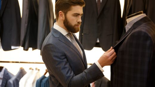 Side view of man choosing a jacket in shop